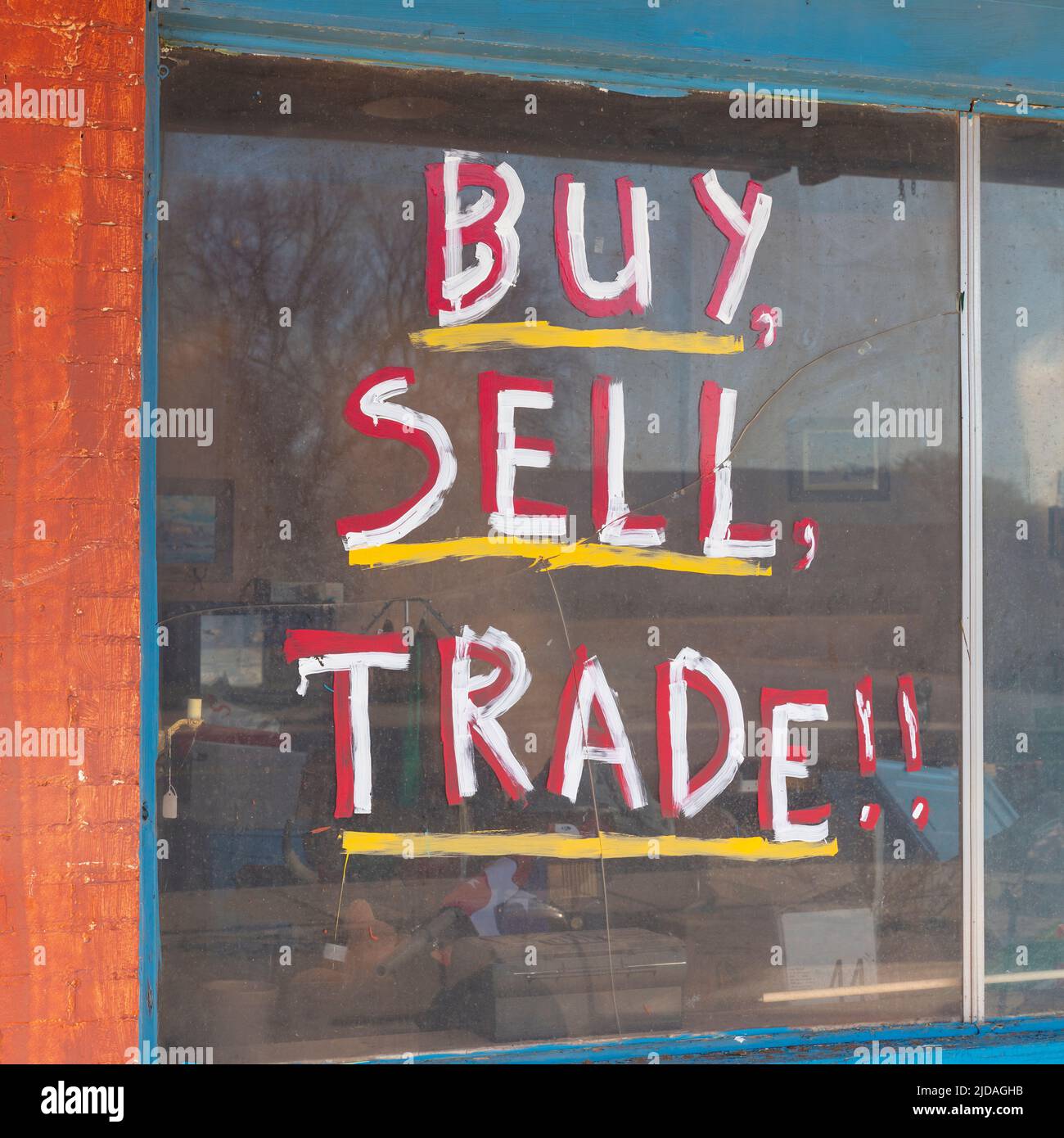 Buy Sell Trade sign in on old storefront window. Stock Photo
