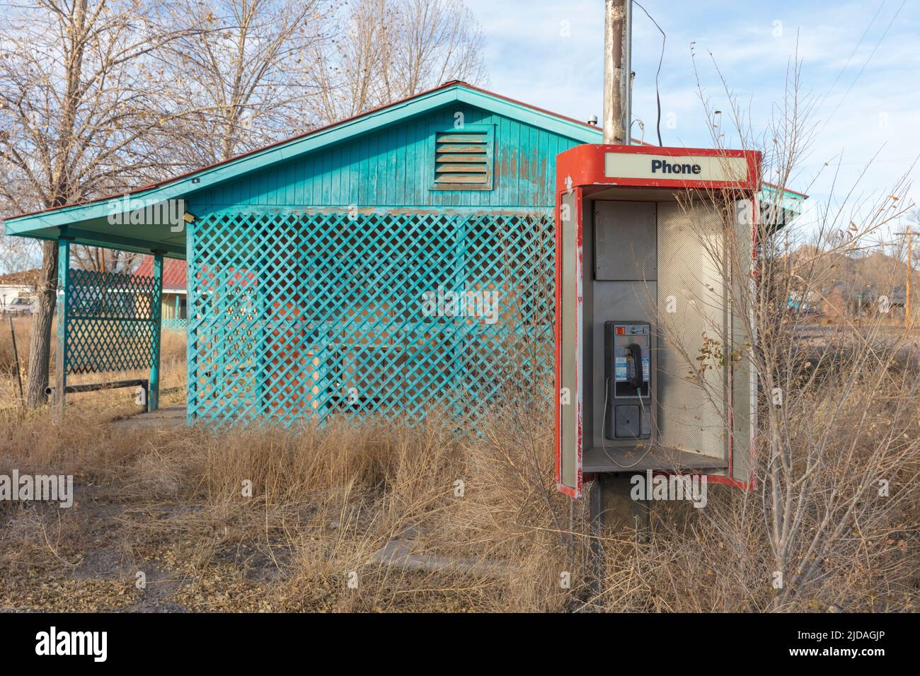 Abandoned old phone booth and deserted store by the roadside. Stock Photo