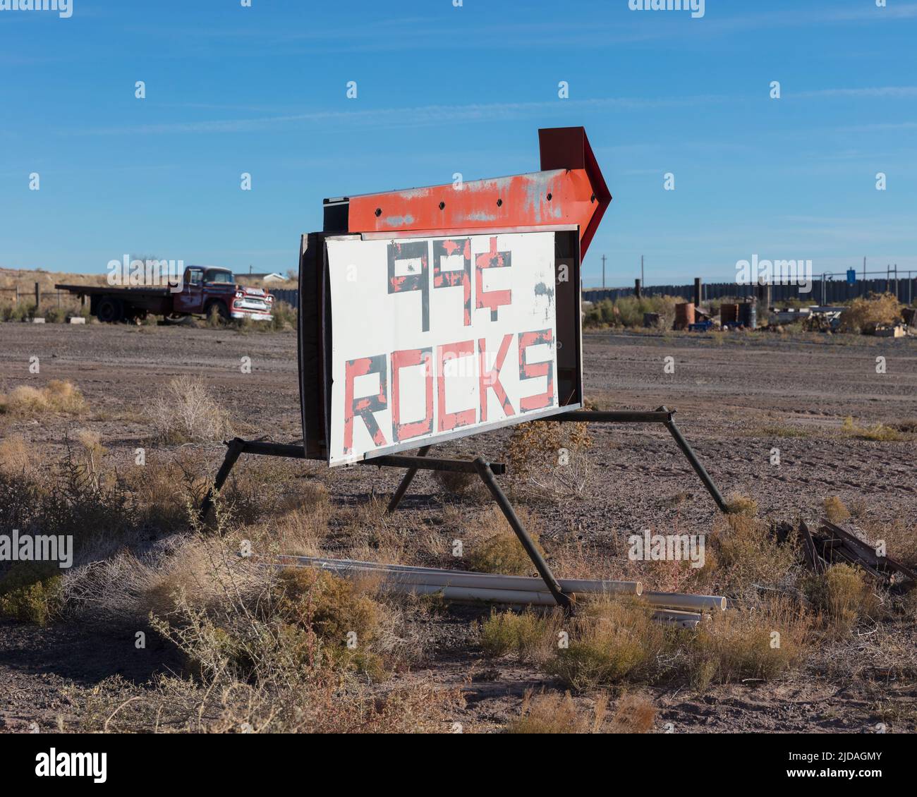 Rusty roadside sign advertising a reststop, deserted trucks and rubbish. Stock Photo