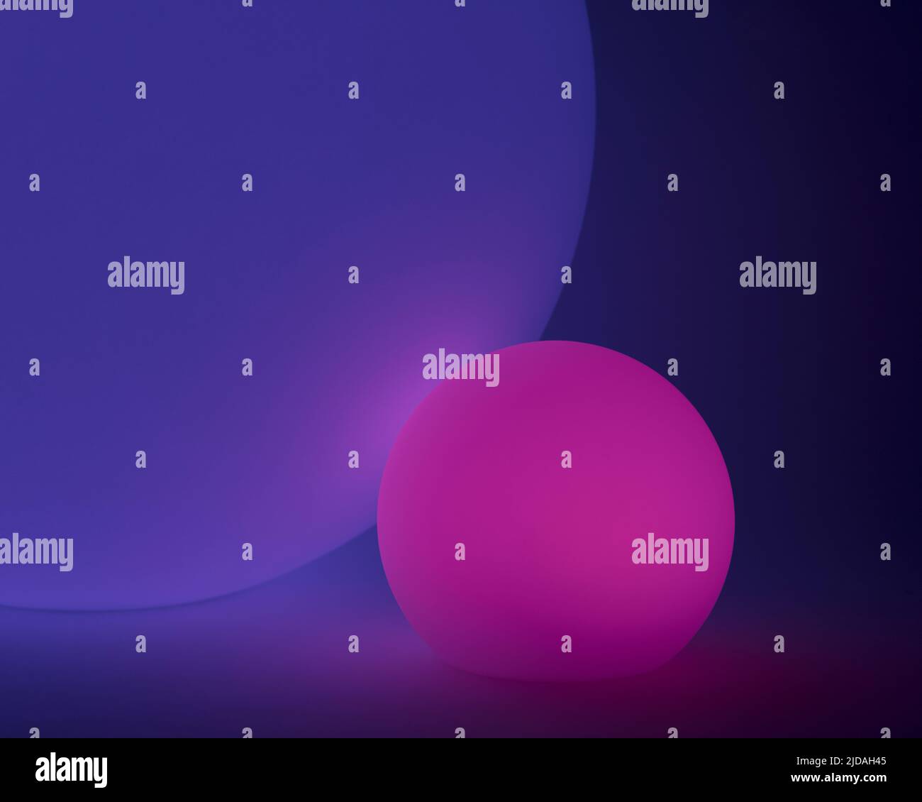 Glowing and illuminated spherical coloured orbs on a black background. Stock Photo