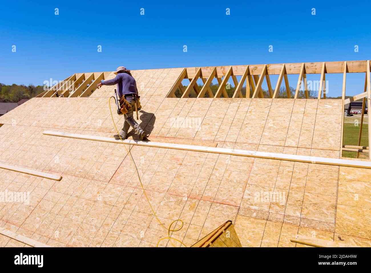Home roof construction applying roof plywood panels in new house Stock
