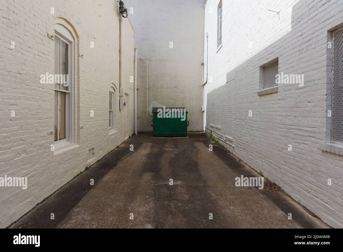 Recycling bin at at end of an urban alleyway in a small town. Stock Photo