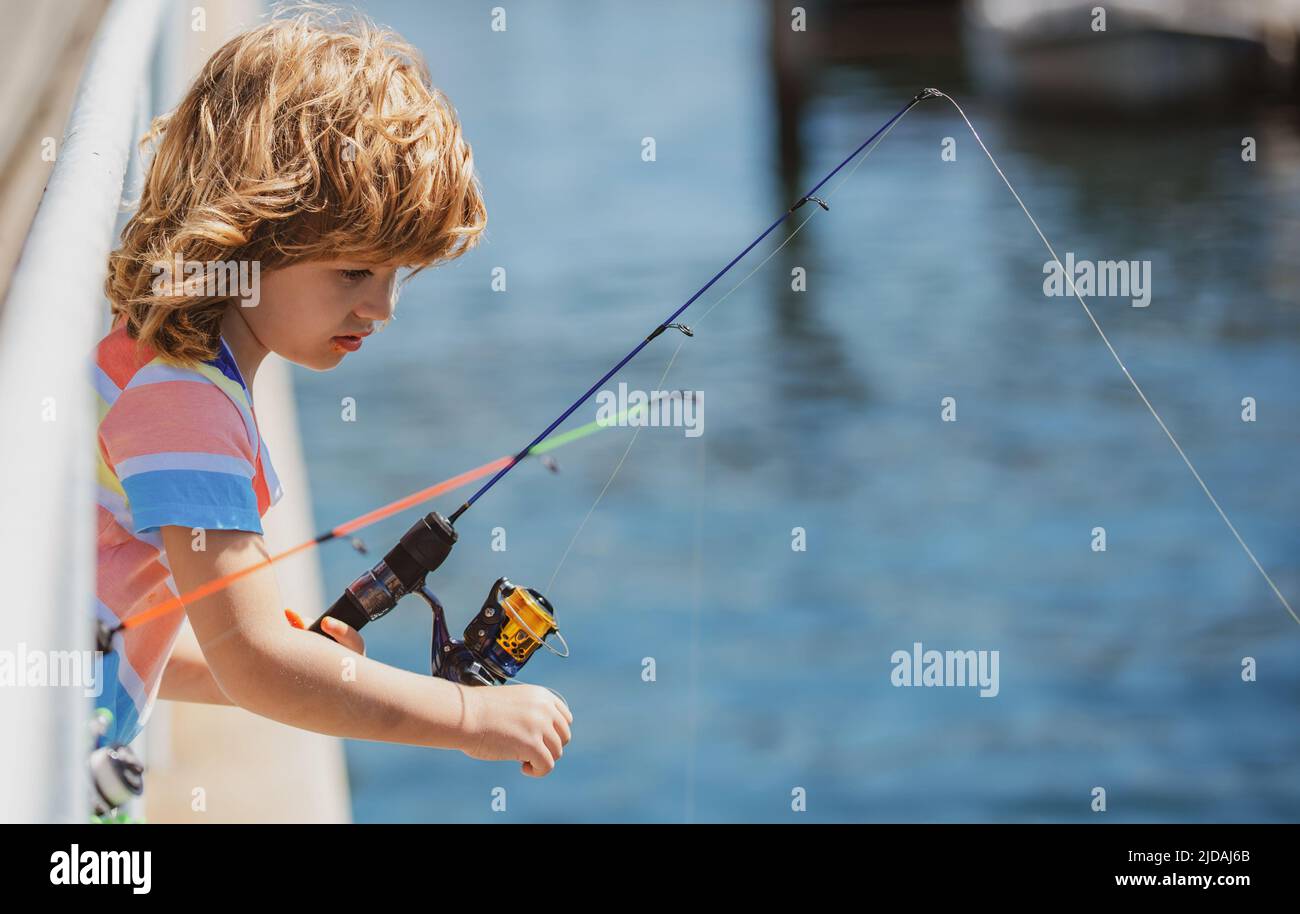 Young boy standing holding fish hi-res stock photography and