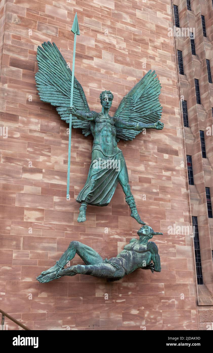 The bronze statue St Michael's Victory over the Devil by Jacob Epstein is mounted on the exterior of the new Coventry cathedral near the entrance. Stock Photo