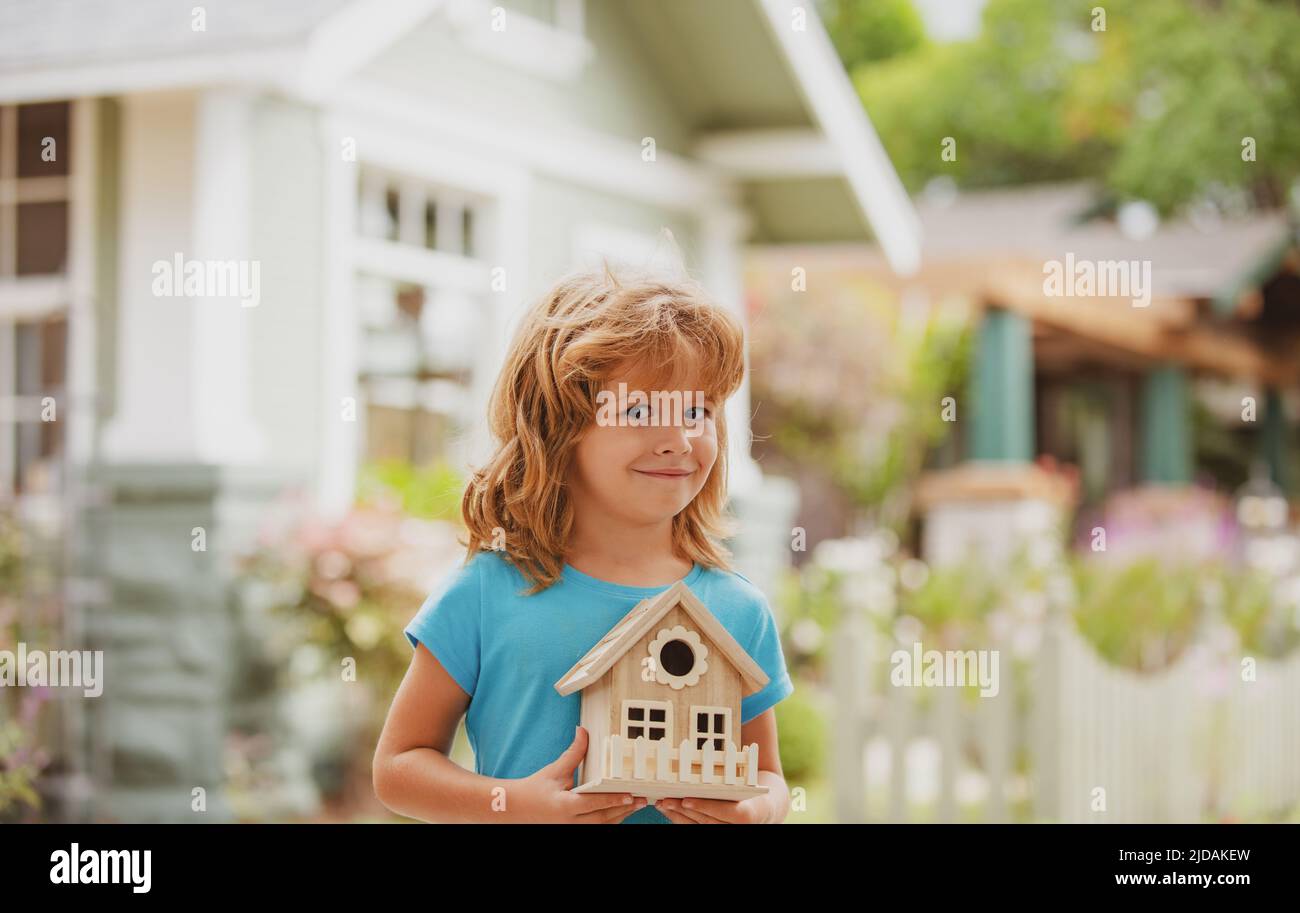 Family home protecting insurance concept, House in kids hands. Child boy building house care. Happy kid needlework concept. Diy project. Stock Photo
