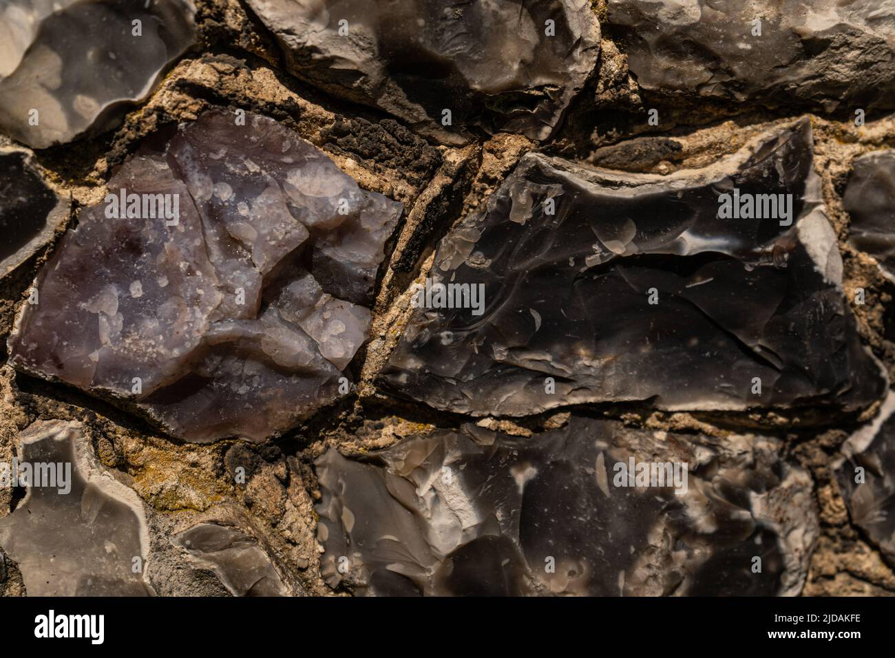 Closeup on various flint stones used in UK as a building material in architecture. Flint is the hardest of building stones, used by the Romans for cas Stock Photo