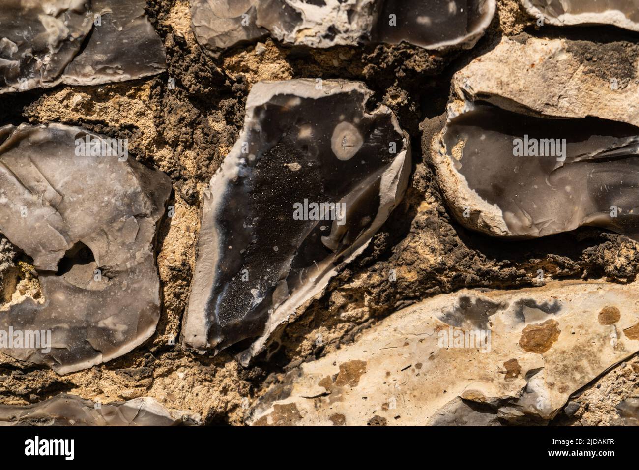 Closeup on various flint stones used in UK as a building material in architecture. Flint is the hardest of building stones, used by the Romans for cas Stock Photo