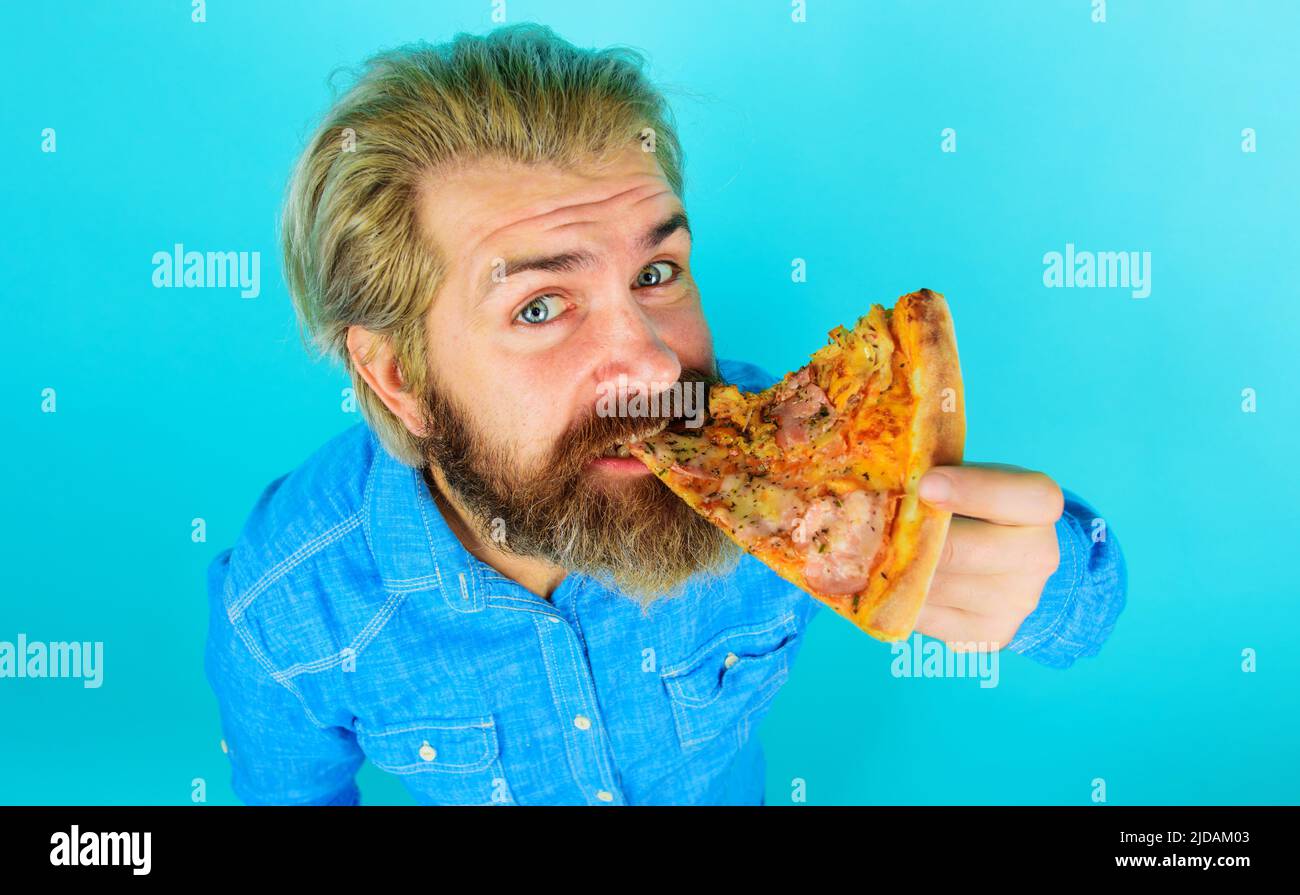 Bearded man eating pizza slice. Delicious fast food meal. Italian cuisine. Lunch or dinner. Stock Photo
