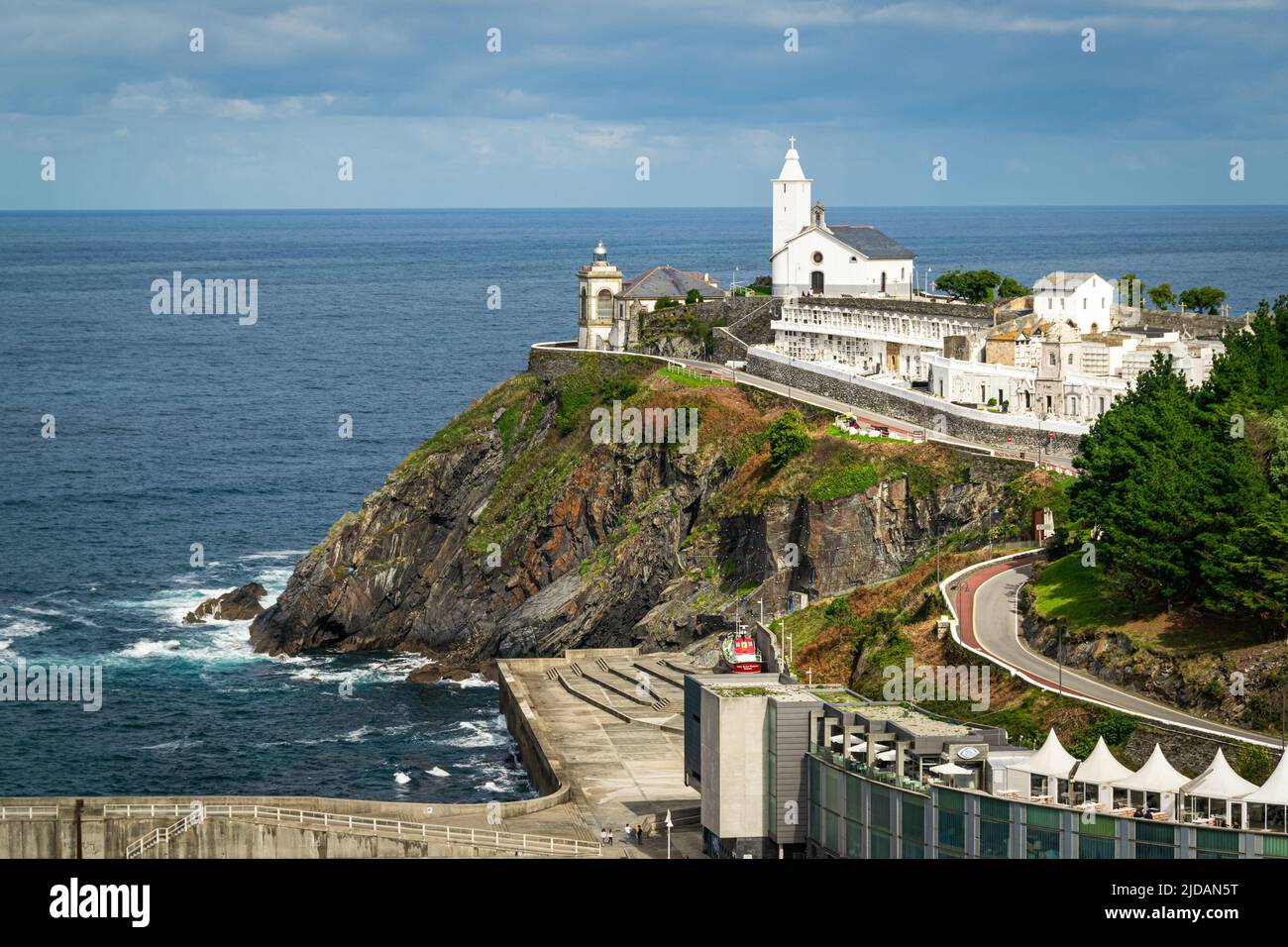 Picturesque chapel with cementery and a lighthouse overlooking Cantabrian sea in the village of Luarca, Asturias, Spain. Stock Photo