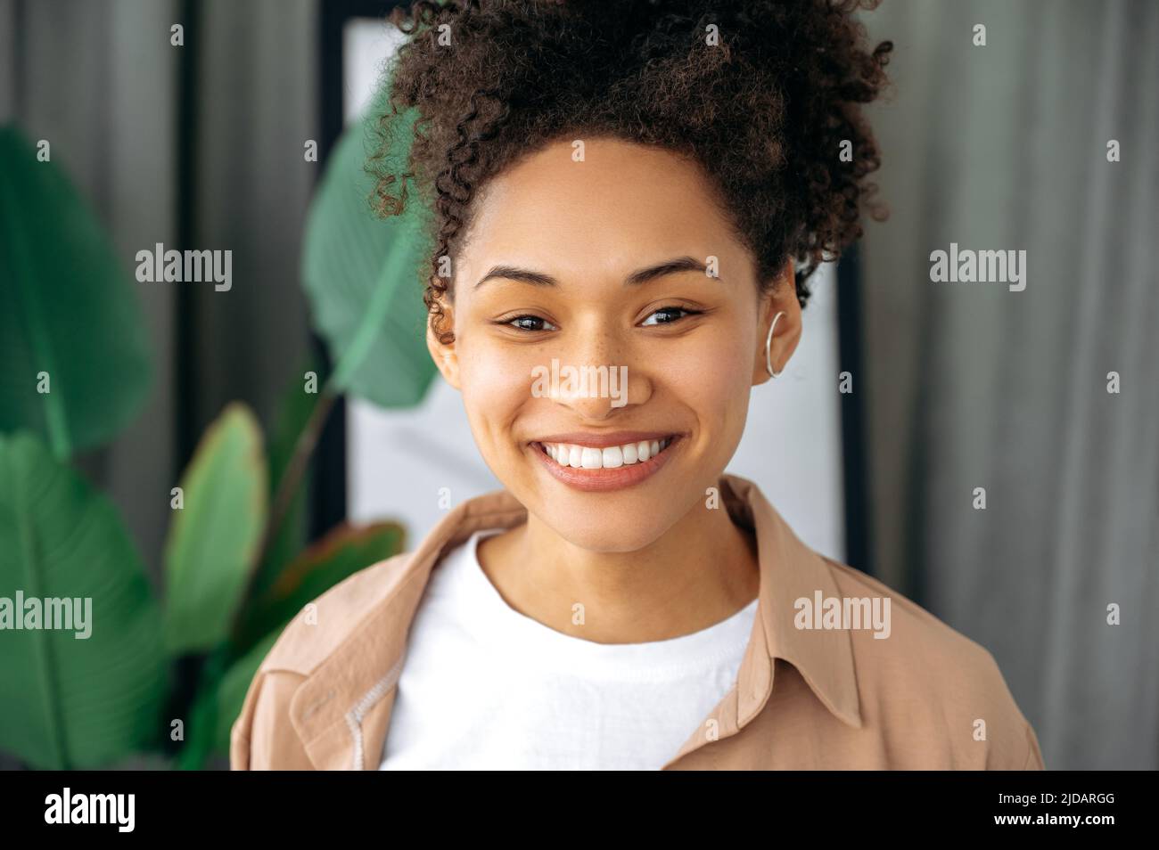 Close-up of a joyful beautiful African American young curly haired ...