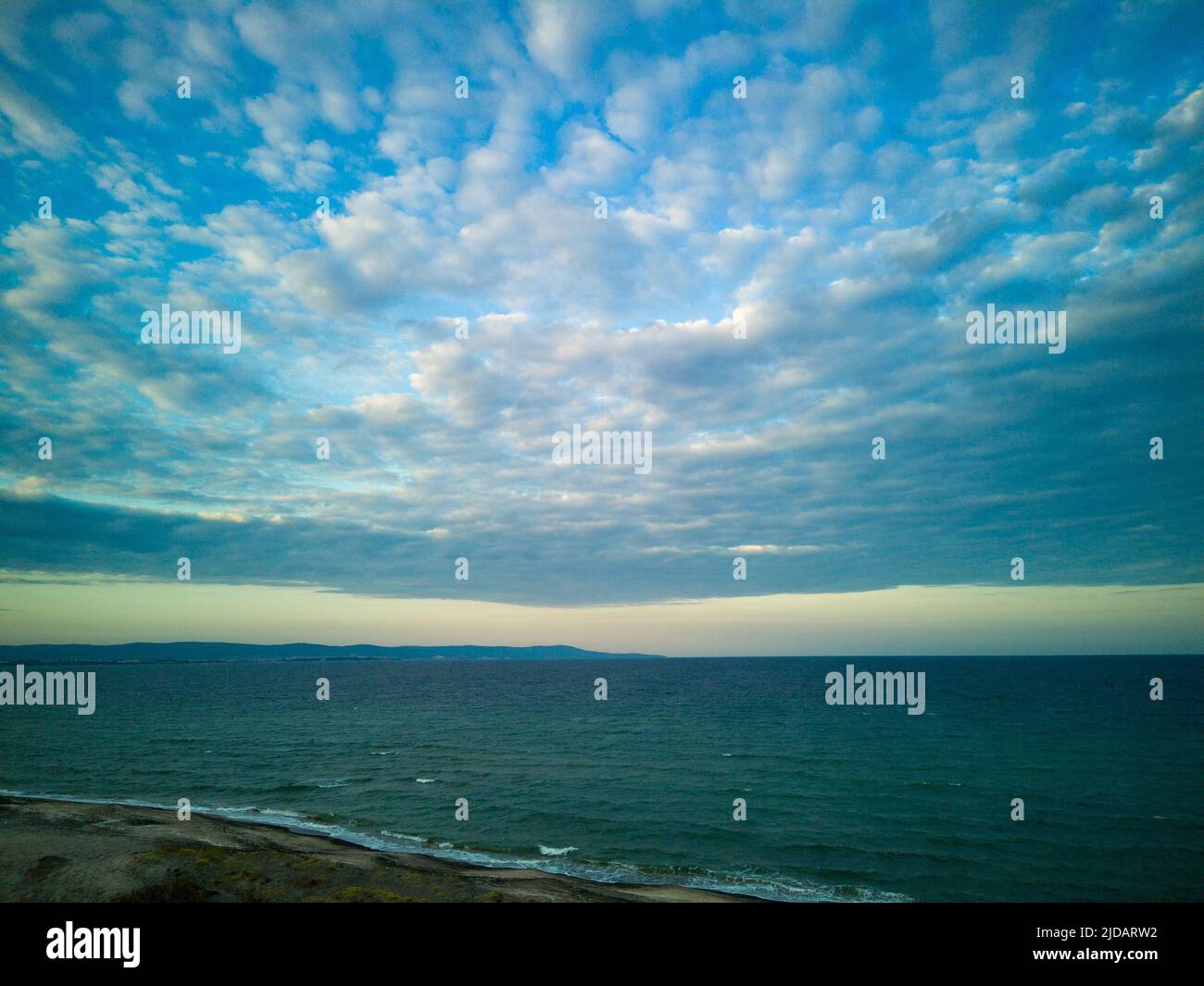 Calm blue boundless Black Sea with cool water reflecting light and sandy  wild empty beach nearby, against cloudy colored sky with white clouds and  bri Stock Photo - Alamy