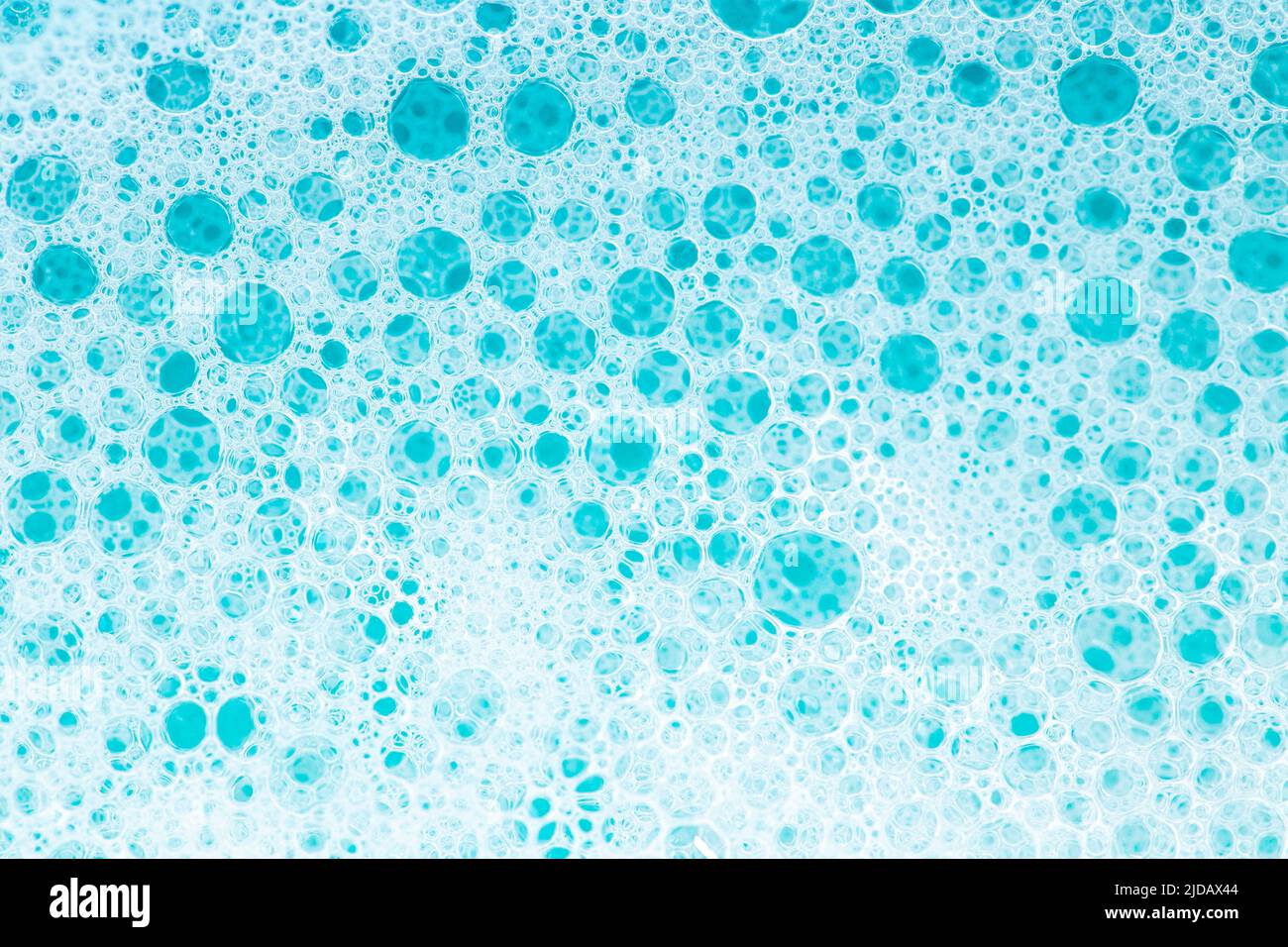 Blue water with white foam bubbles.Cleanliness and hygiene background. Foam Water Soap Suds.Texture Foam Close-up. blue soap bubbles .Laundry and Stock Photo