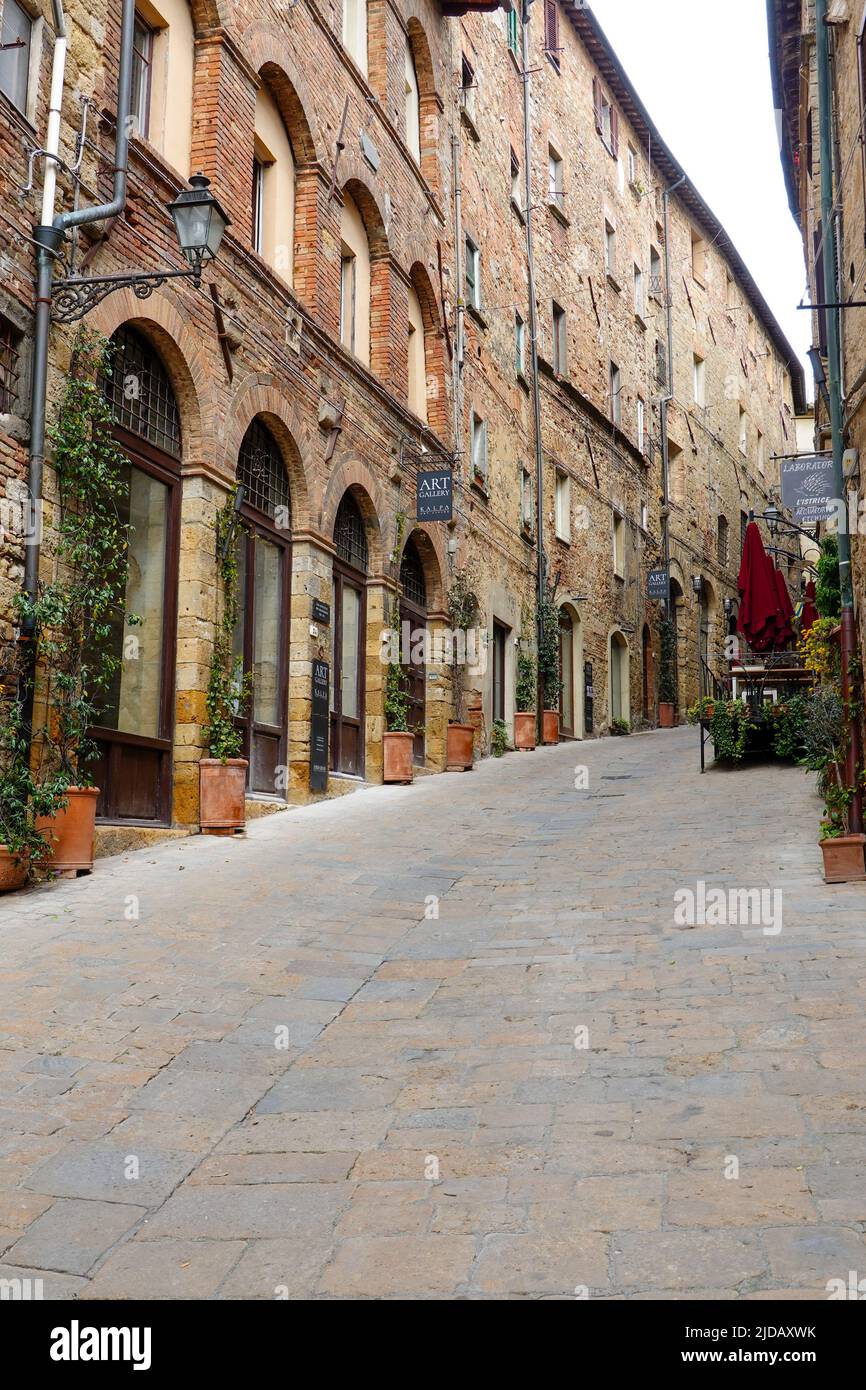 Via Porta all'Arco, a pedestrian street with shops, galleries and residential apartments in Volterra, Italy. Stock Photo