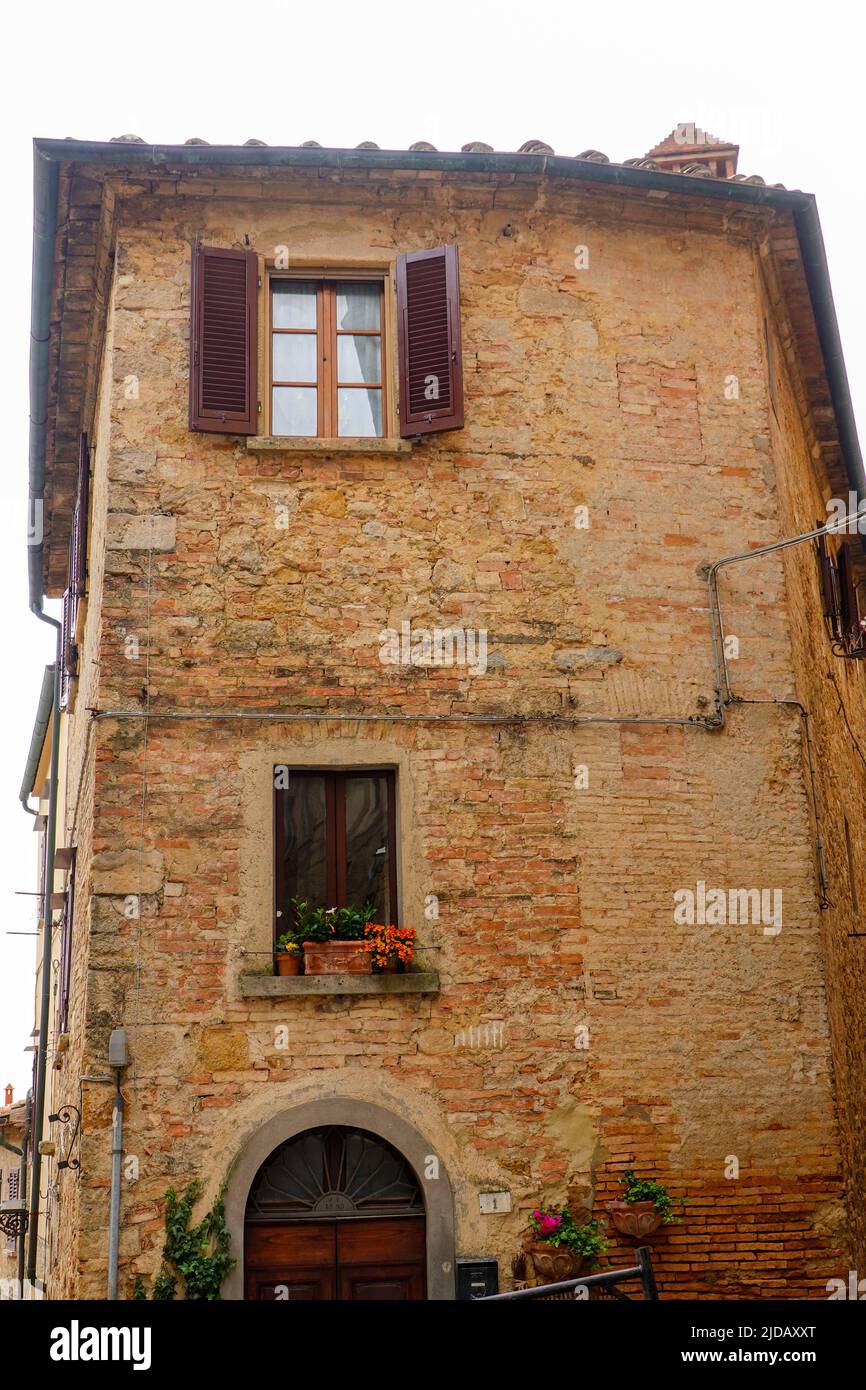 Side of building off Via Porta all'Arco, a pedestrian street in Volterra, Italy. Stock Photo