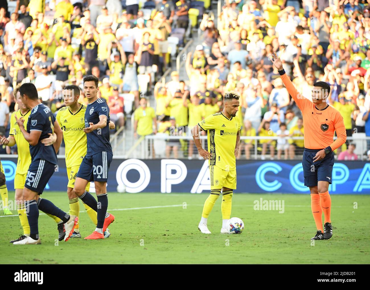 Nashville, USA. June 19, 2022: Referee issues Sporting Kansas City midfielder Roger Espinoza (15) a yellow card against the Nashville SC during the second half of an MLS game between Sporting Kansas City and Nashville SC at Geodis Park in Nashville TN Steve Roberts/CSM Credit: Cal Sport Media/Alamy Live News Stock Photo