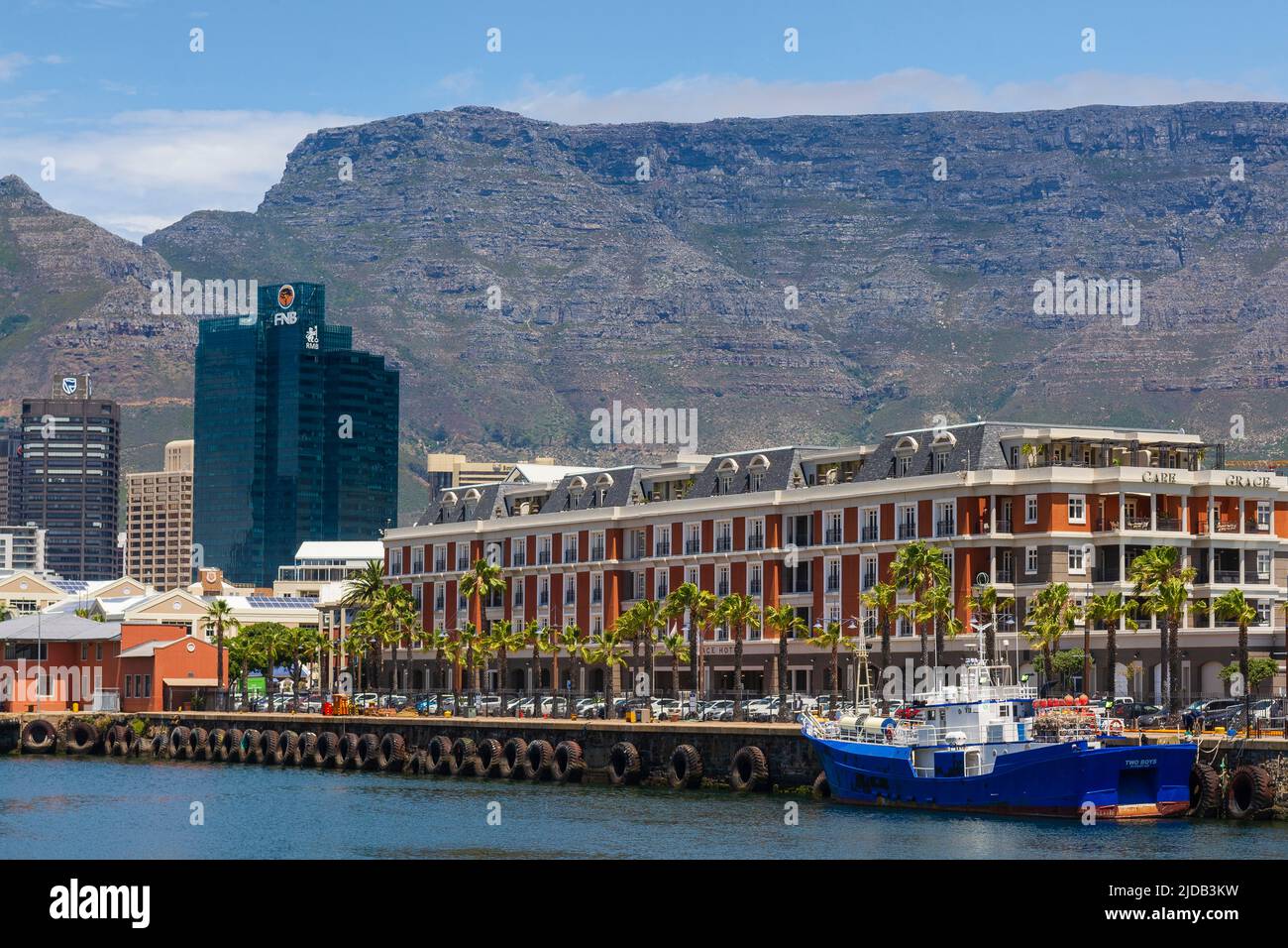 The Cape Grace Hotel with office buildings and Table Mountain in the background along the harbor at the Victoria and Alfred Waterfront in Cape Town Stock Photo