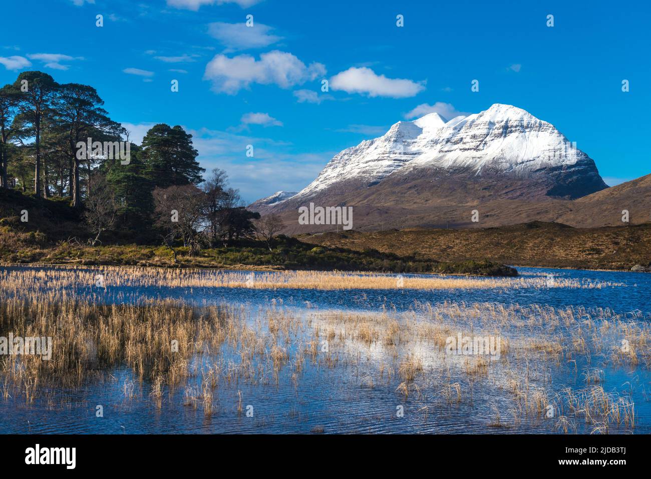 Looking across small lochen to Liathach covered in snow, Glen Torridon; Scotland, United Kingdom Stock Photo