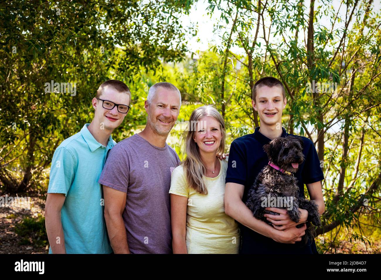 Outdoor family portrait in a park with two teenage sons and a dog