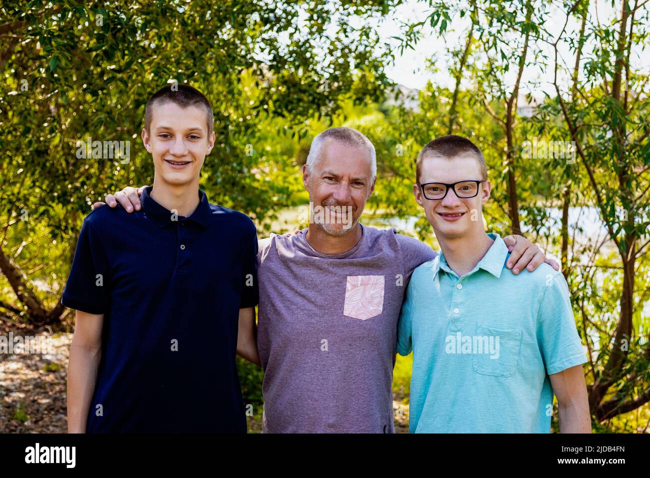 Outdoor portrait of a father with two sons; Edmonton, Alberta, Canada Stock Photo