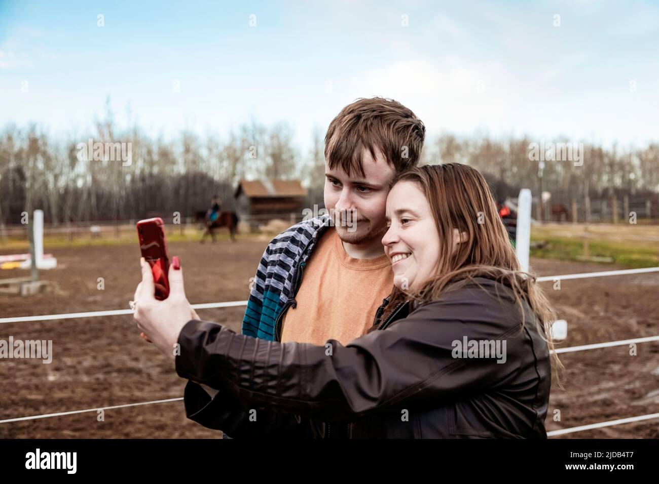 A mom with epilepsy taking a self-portrait with her son who has Aspberger Syndrome at an equine centre; Westlock, Alberta, Canada Stock Photo