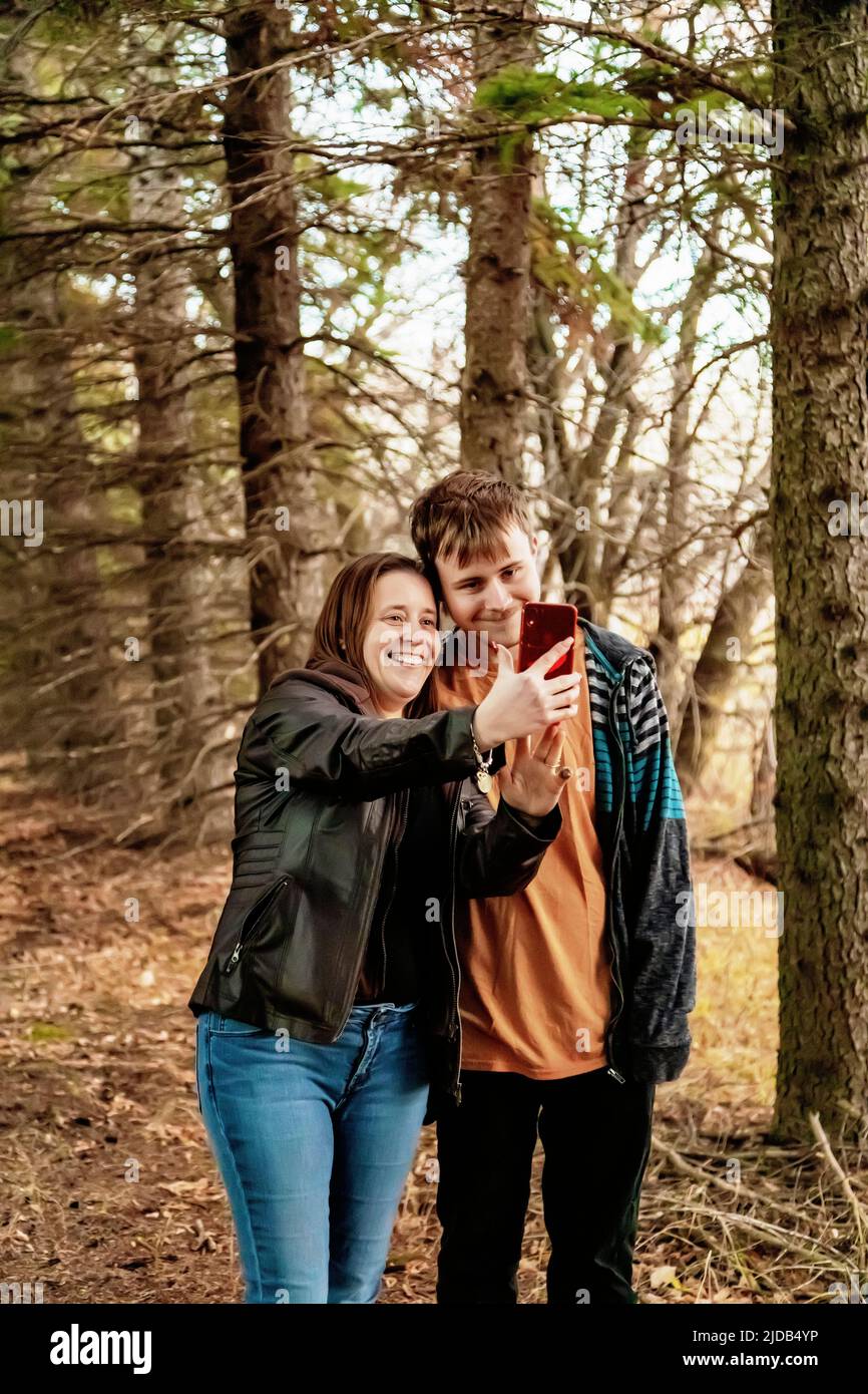 A mother with epilepsy taking a self-portrait with her son who has Aspberger Syndrome in a field on a farm after harvest; Westlock, Alberta, Canada Stock Photo