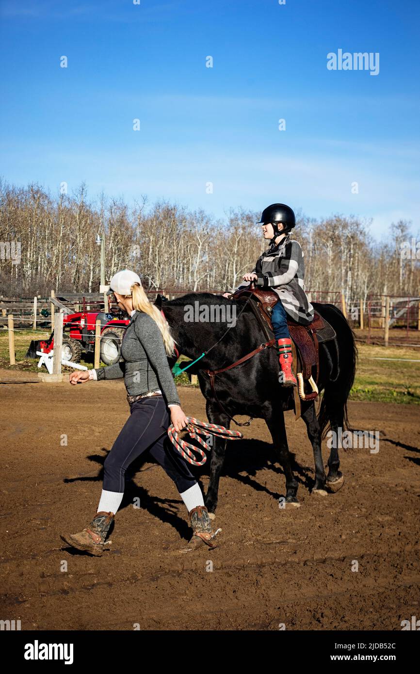 A young girl with Cerebral Palsy and her trainer working with a horse