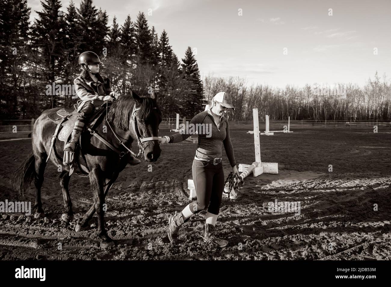 A trainer working with a young girl with Cerebral Palsy during a Hippotherapy session; Westlock, Alberta, Canada Stock Photo