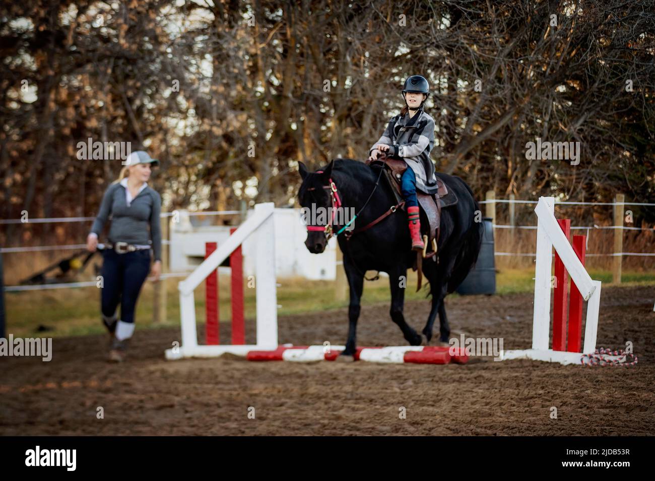 A young girl with Cerebral Palsy and her trainer working with a horse