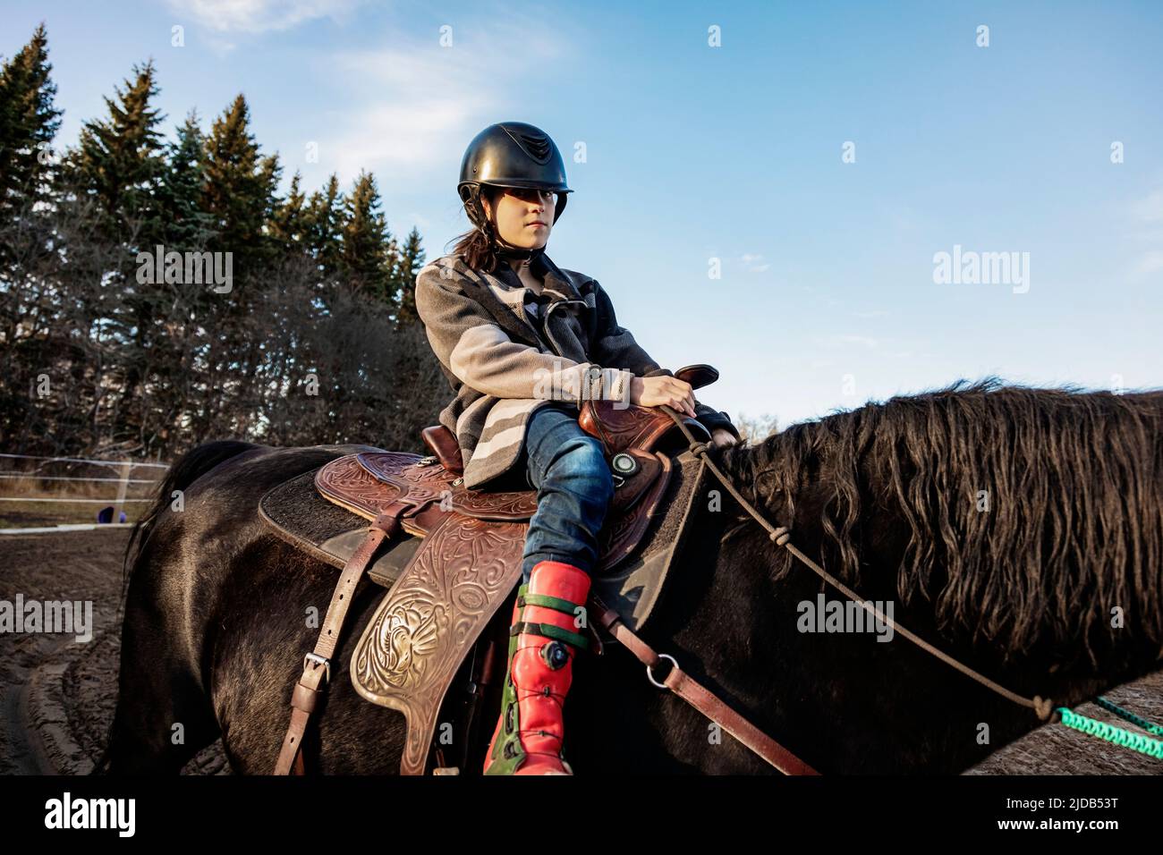 A young girl with Cerebral Palsy riding a horse during a Hippotherapy session; Westlock, Alberta, Canada Stock Photo