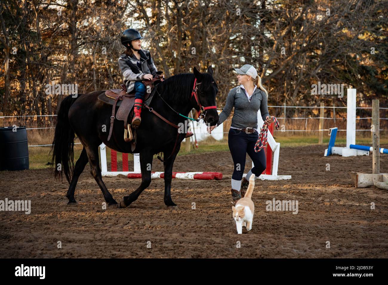 A young girl with Cerebral Palsy and her trainer working with a horse