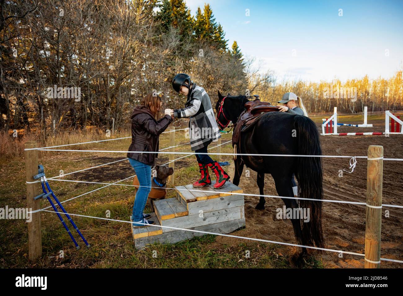 A young girl with Cerebral Palsy getting off her horse during a