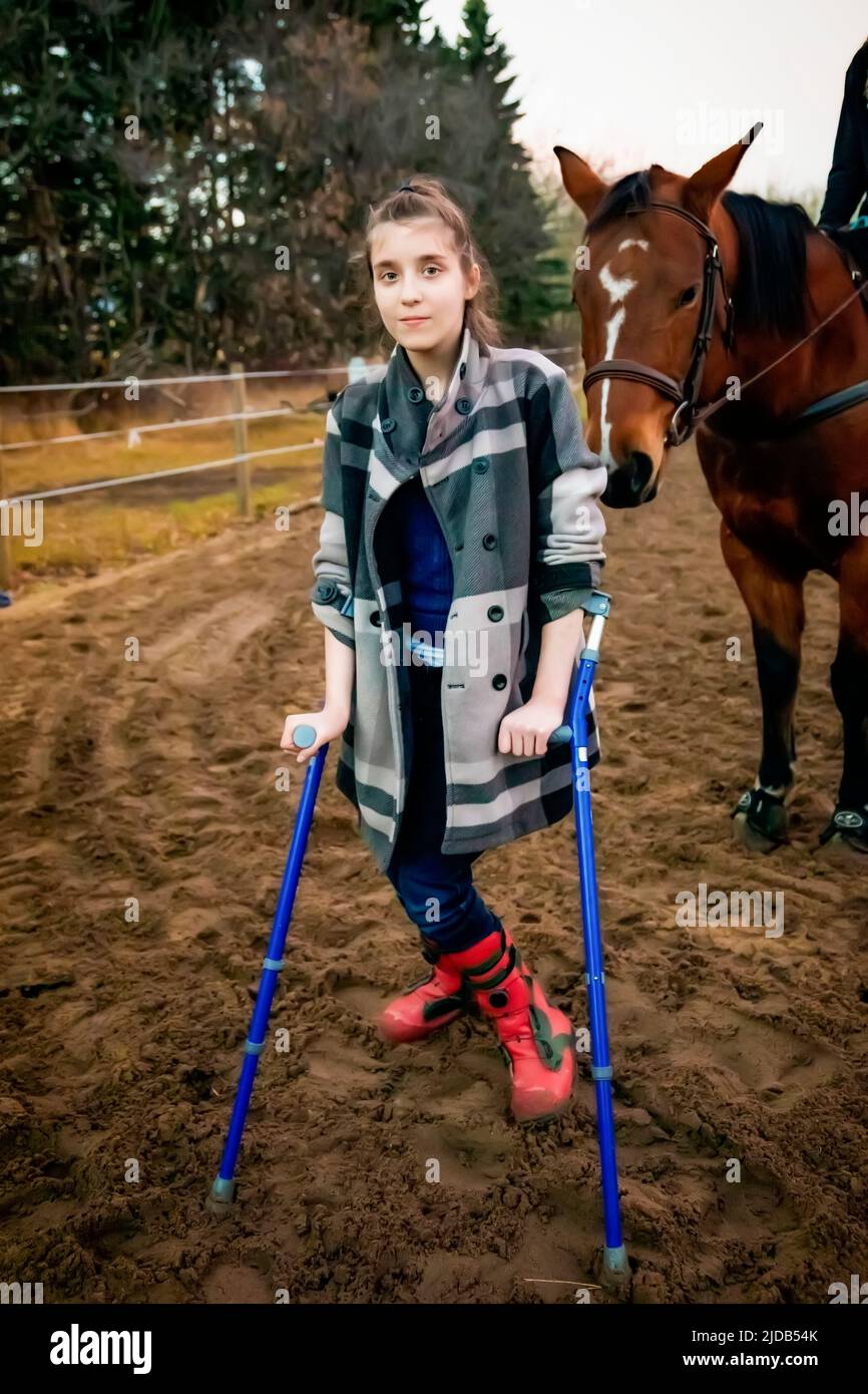 A young girl with Cerebral Palsy walking in a corral during a Hippotherapy session; Westlock, Alberta, Canada Stock Photo