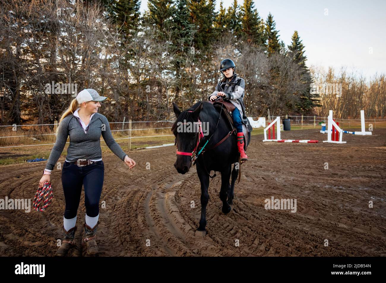 A young girl with Cerebral Palsy and her trainer working with a horse during a Hippotherapy session; Westlock, Alberta, Canada Stock Photo