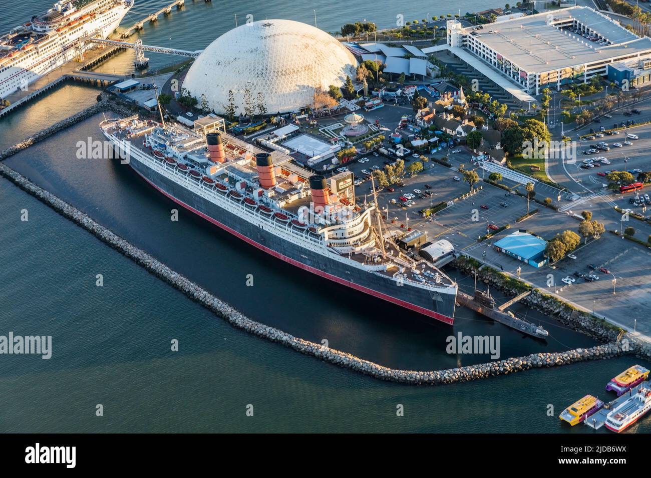 RMS Queen Mary, now a hotel ship and tourist attraction at Long Beach, California.  Dome is former home of Howard Hughes' Spruce Goose. Stock Photo