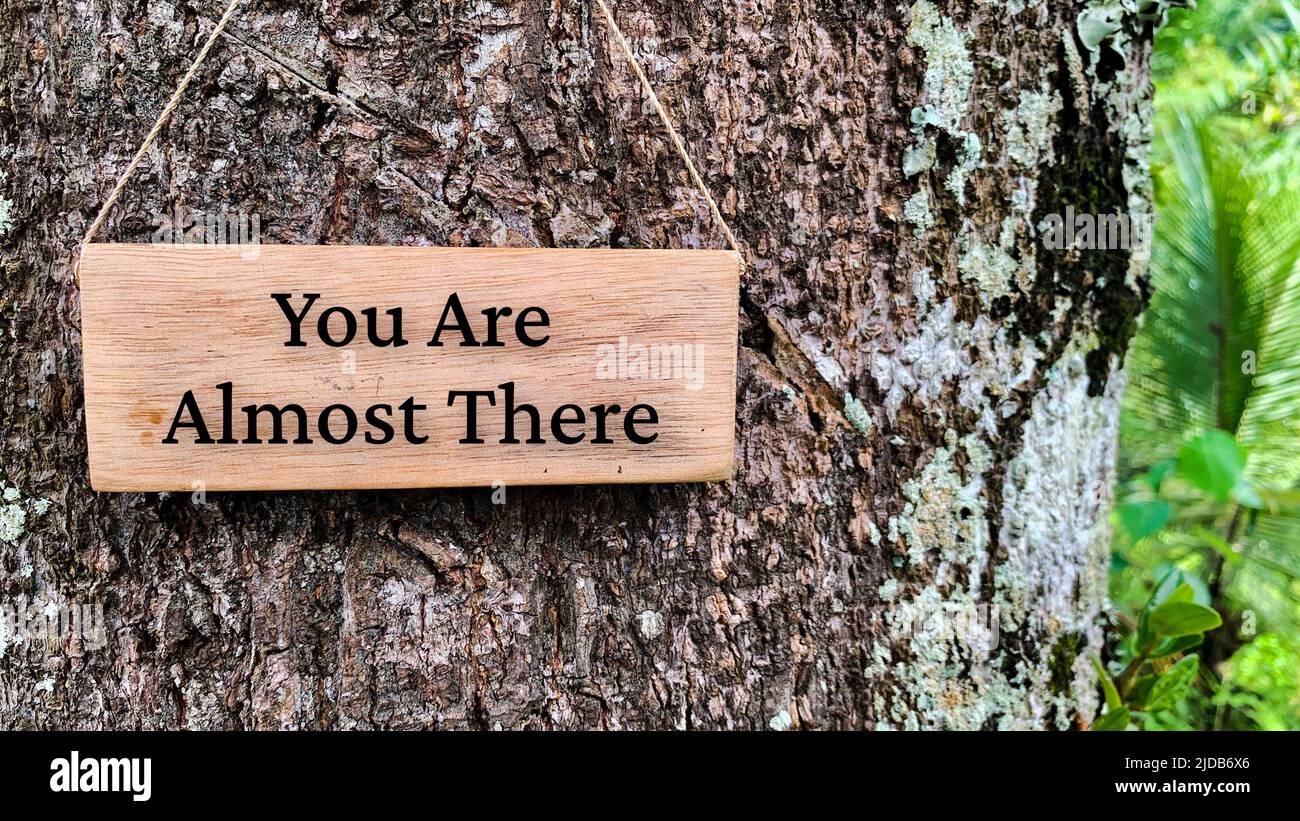 Inspirational quote text on wooden banner - You are almost there. With tree and nature background. Inspirational concept Stock Photo