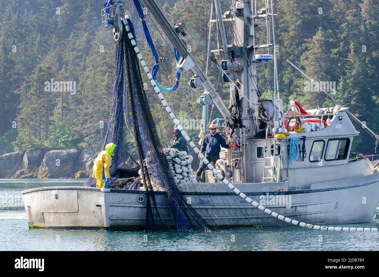 A salmon purse seiner and crew work the waters of Kachemak Bay for returning fish during the summer season in 2019. Stock Photo