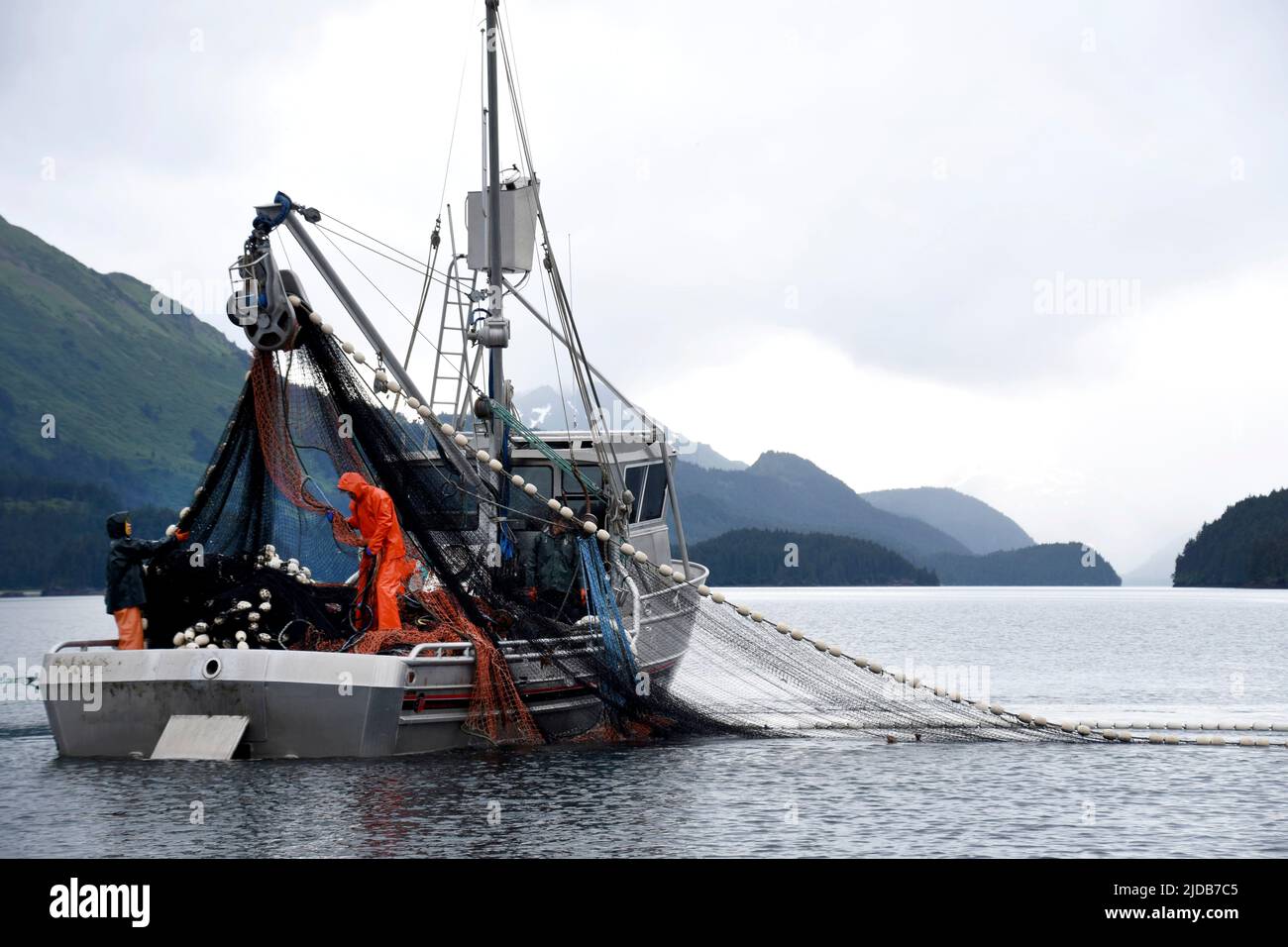 A salmon purse seiner and crew work the waters of Kachemak Bay for returning fish during the summer season in 2018. Stock Photo