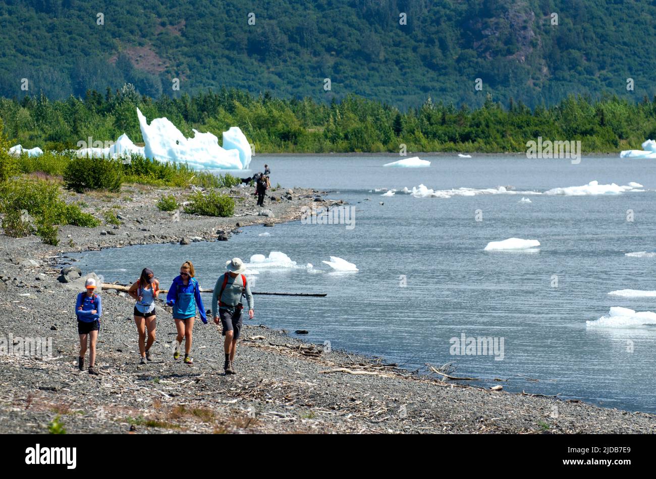 Hikers move along the shore at Grewingk Glacier lake in Kachemak Bay Park, across from Homer, Alaska. Stock Photo