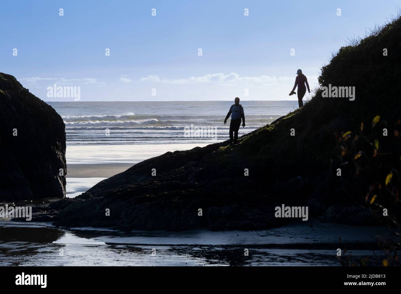 Two people walking on the rugged coastline and exploring the coast of Pacific Rim National Park Reserve, Vancouver Island Stock Photo
