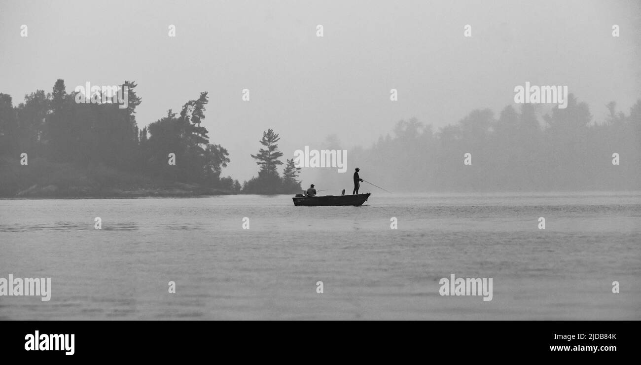 Boating and fishing on a lake with fog, Lake of the Woods, Ontario; Kenora, Ontario, Canada Stock Photo
