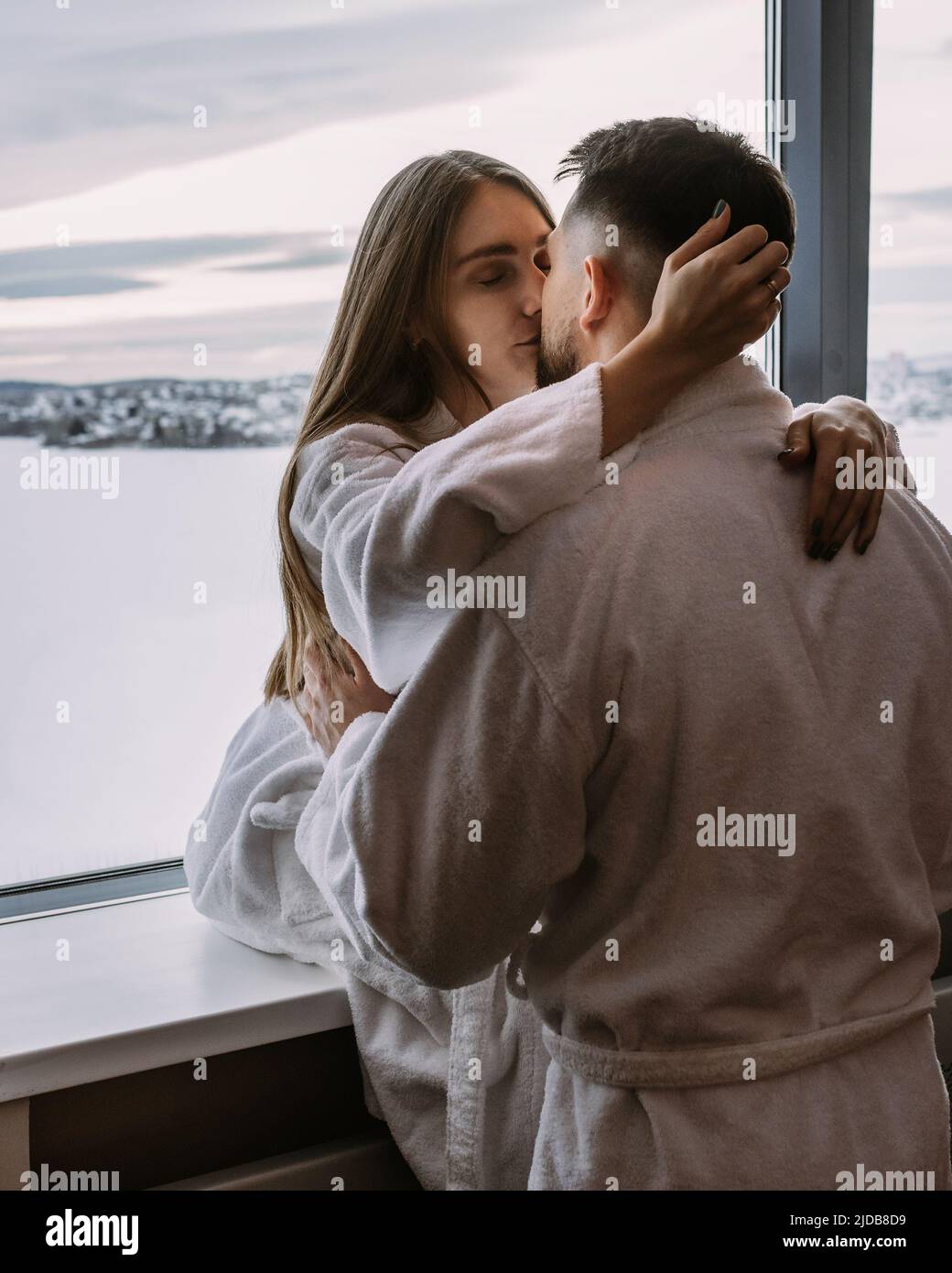 Happy couple in the hotel on window kiss and hug each other Stock Photo