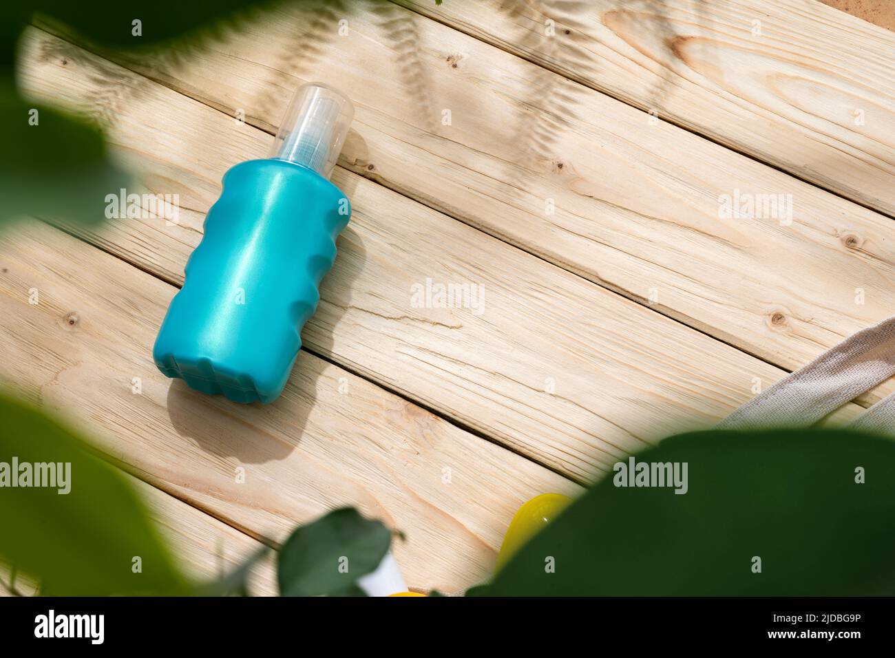 Bottle with sun protection cream on wooden background, top view Stock Photo