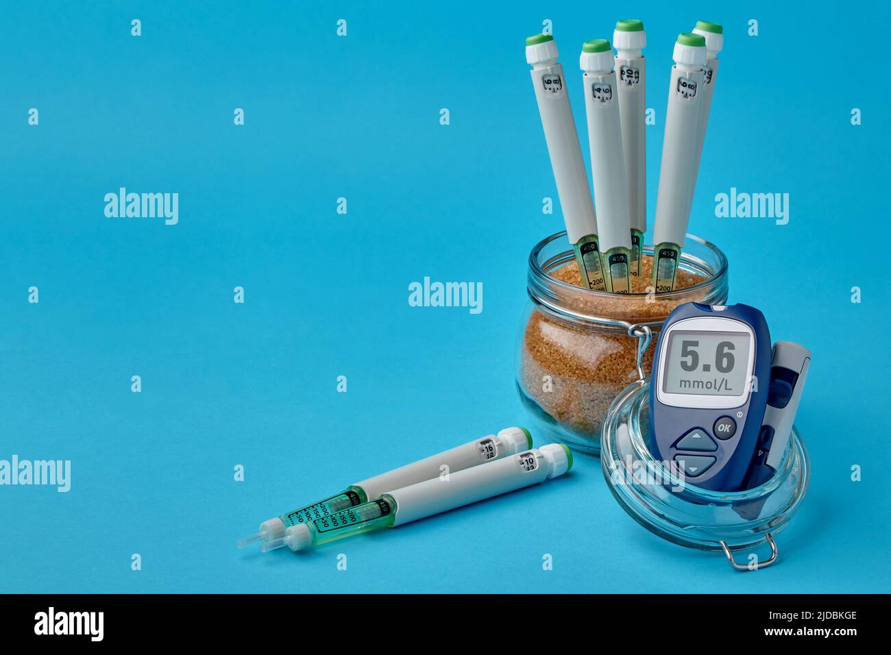 Insulin syringe pens in a jar with brown sugar and a on a