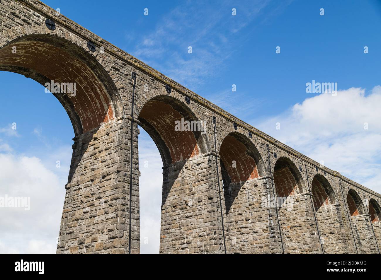 Looking up at the Ribblehead Viaduct under a bright sky pictured in the Yorkshire Dales in June 2022. Stock Photo