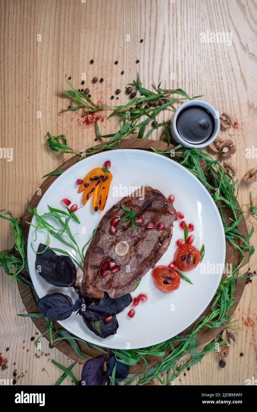 top view of grilled ribeye beef steak with spice, herb and sauce on white plate Stock Photo