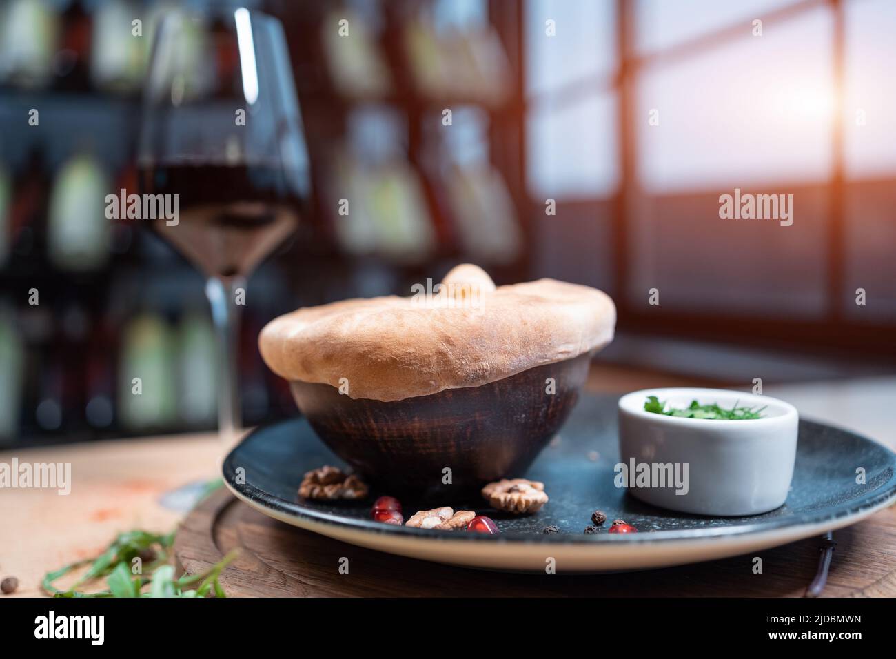 bowl with soup covered with baked crusty dough and with sauce Stock Photo
