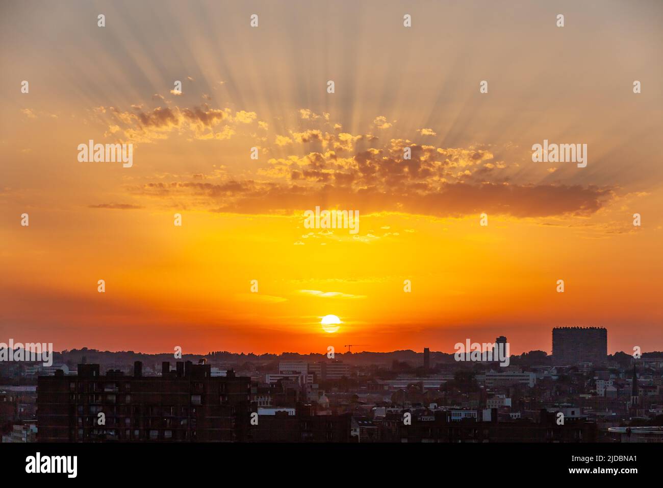 Sunset over the city, sun rays through clouds. Brussels Stock Photo