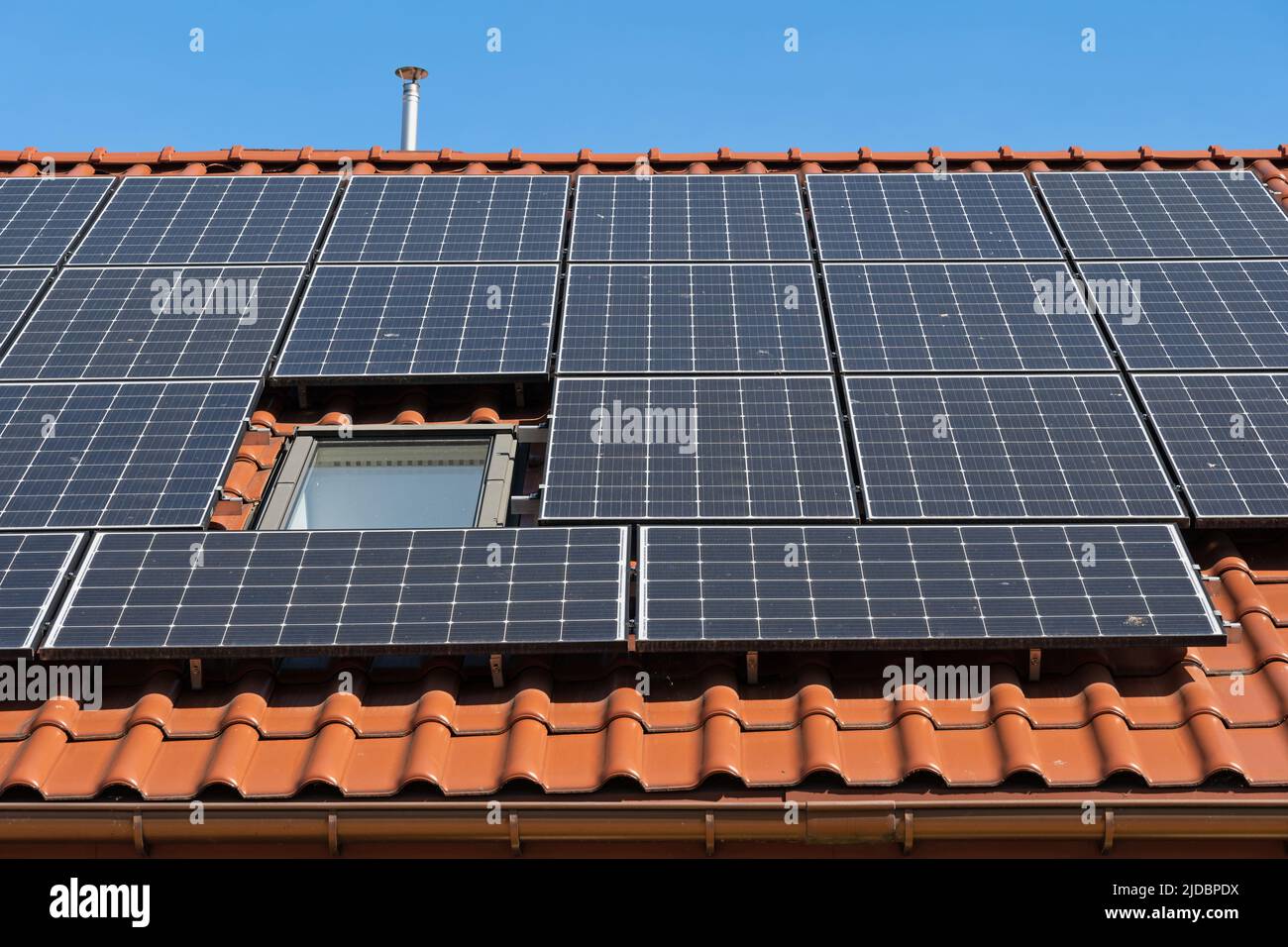 Solar panels installed on house roof, photovoltaic system converting energy from sunlight into clean, emission-free electricity to power a home all ye Stock Photo