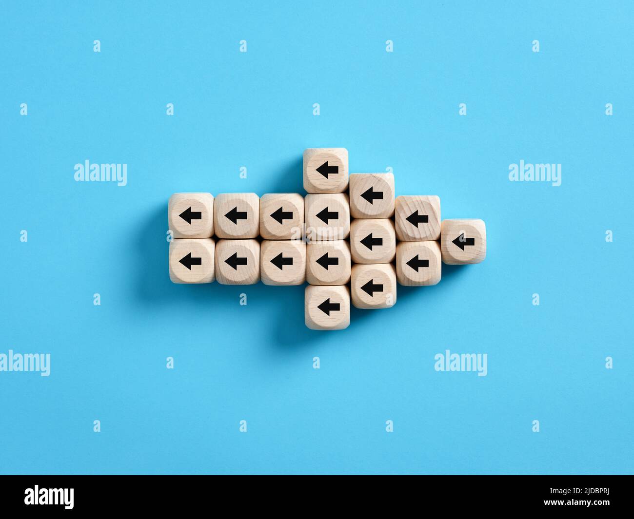 Arrow icon made of wooden cubes with little arrow icons pointing opposite direction. Resistance to change in business concept. Stock Photo