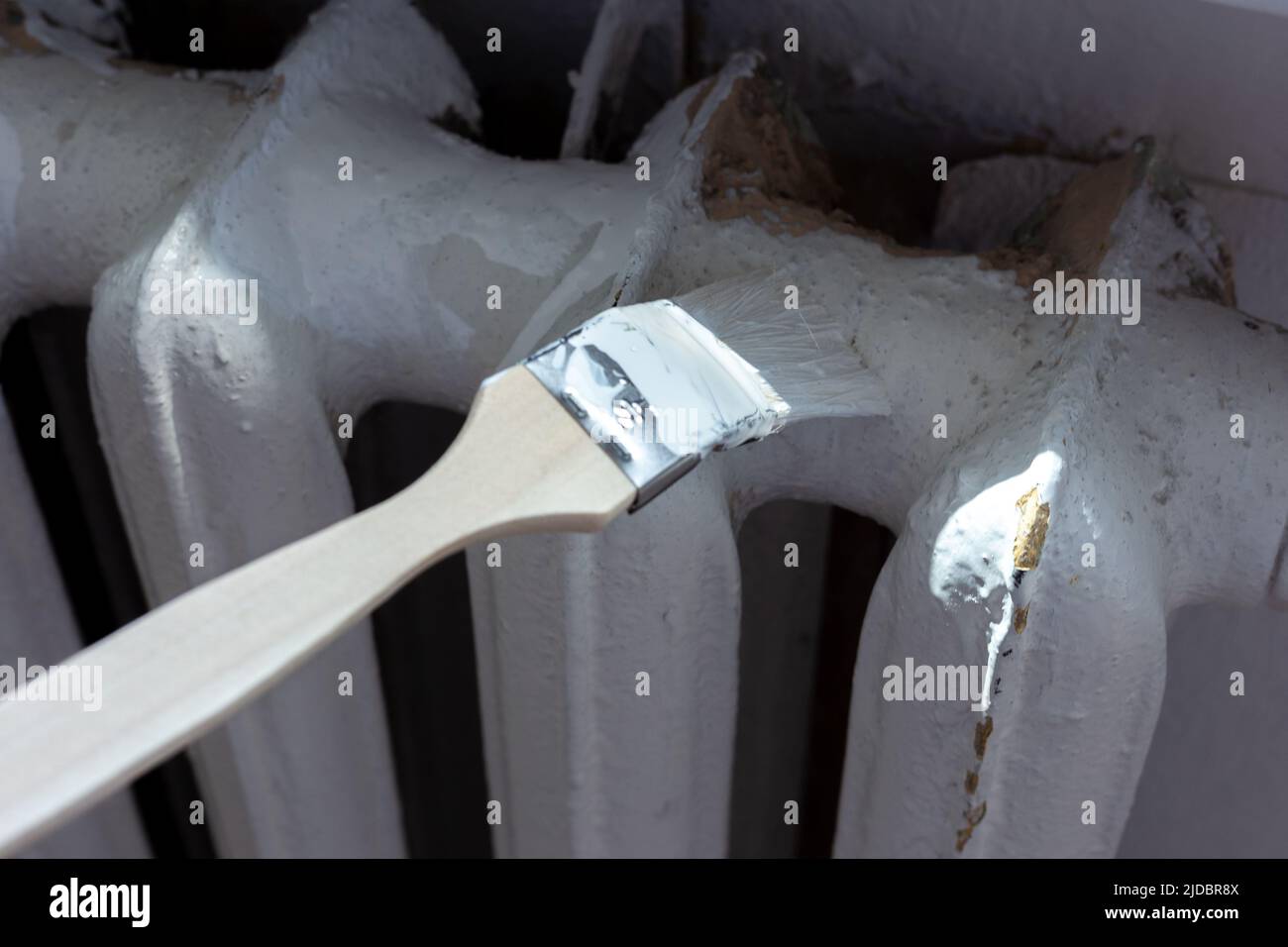 Painting radiators with a special brush. Battery painting Stock Photo
